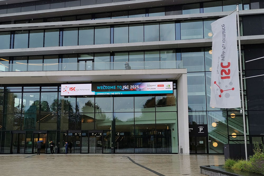 Conference building entrance with ISC 2025 banner and vertical flag outside.